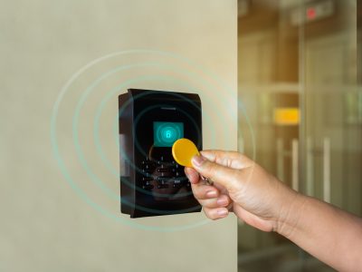 A door access control system. young person holding a key card to lock and unlock door to entry building is security system. A door access control system. young person holding a key card to lock and unlock door to entry building is security system.